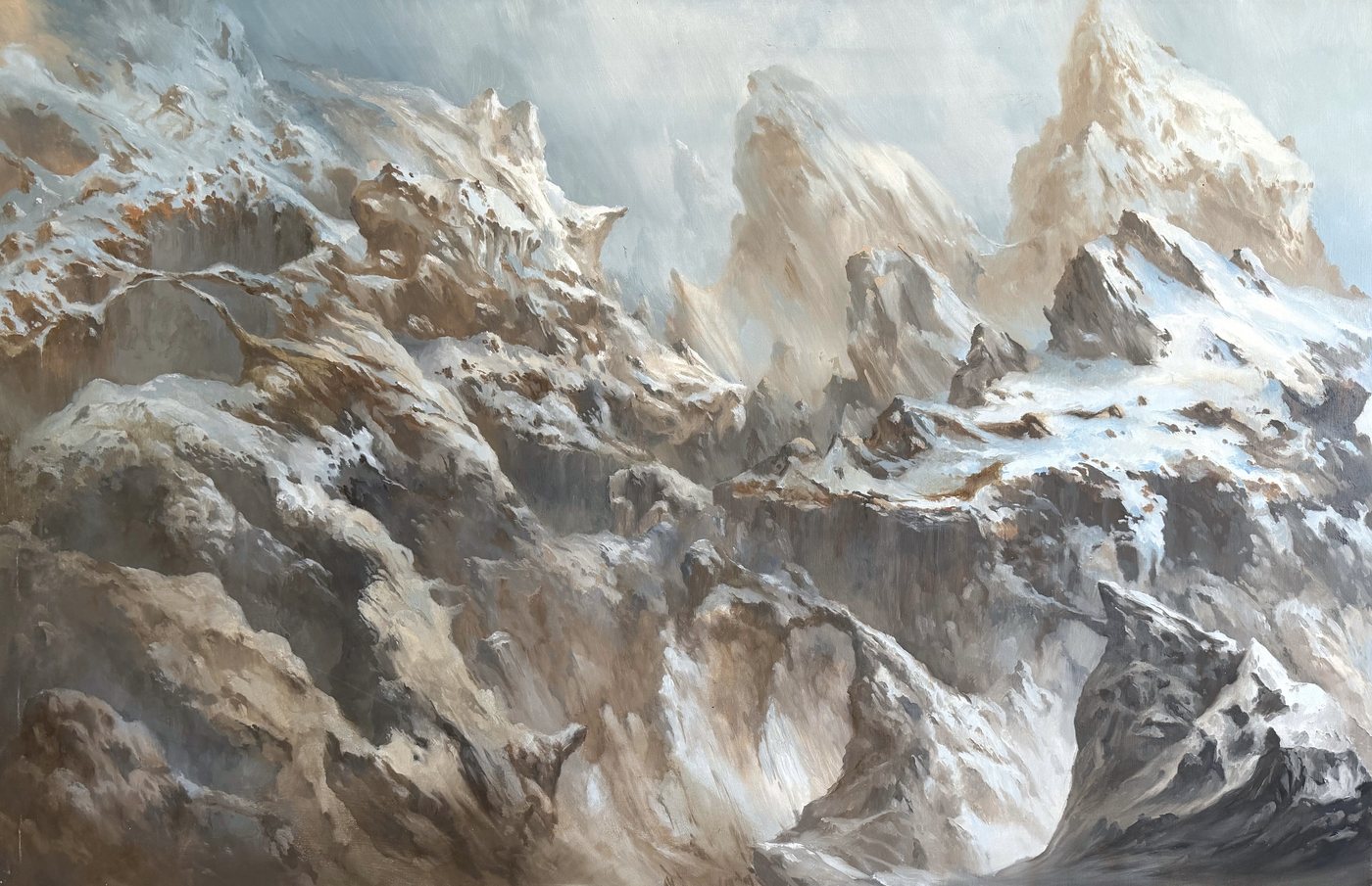 Chaîne de montagnes enneigées, ocre et blanche, sous une lumière froide.